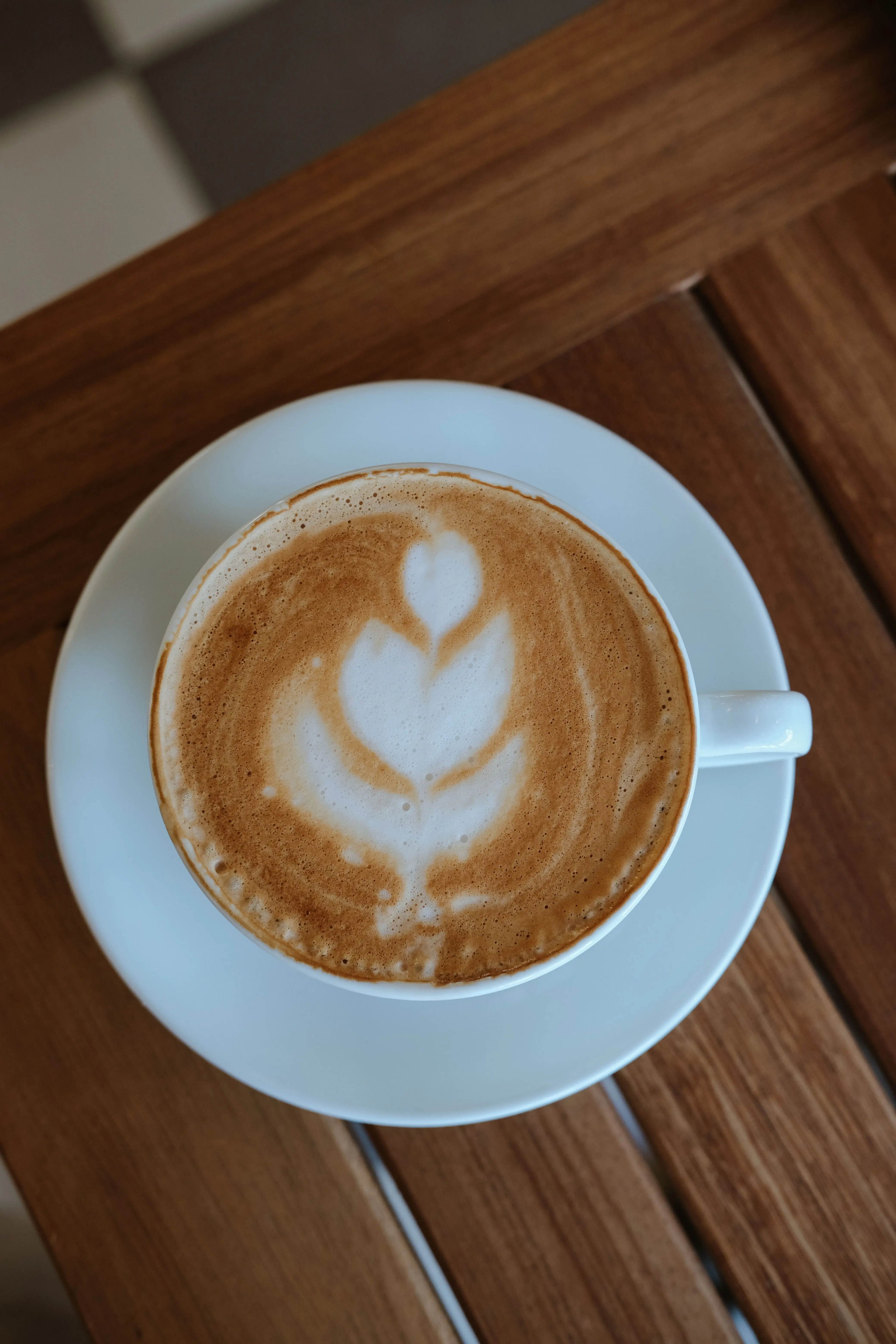 Cappuccino mit Latte Art auf einem Holztisch